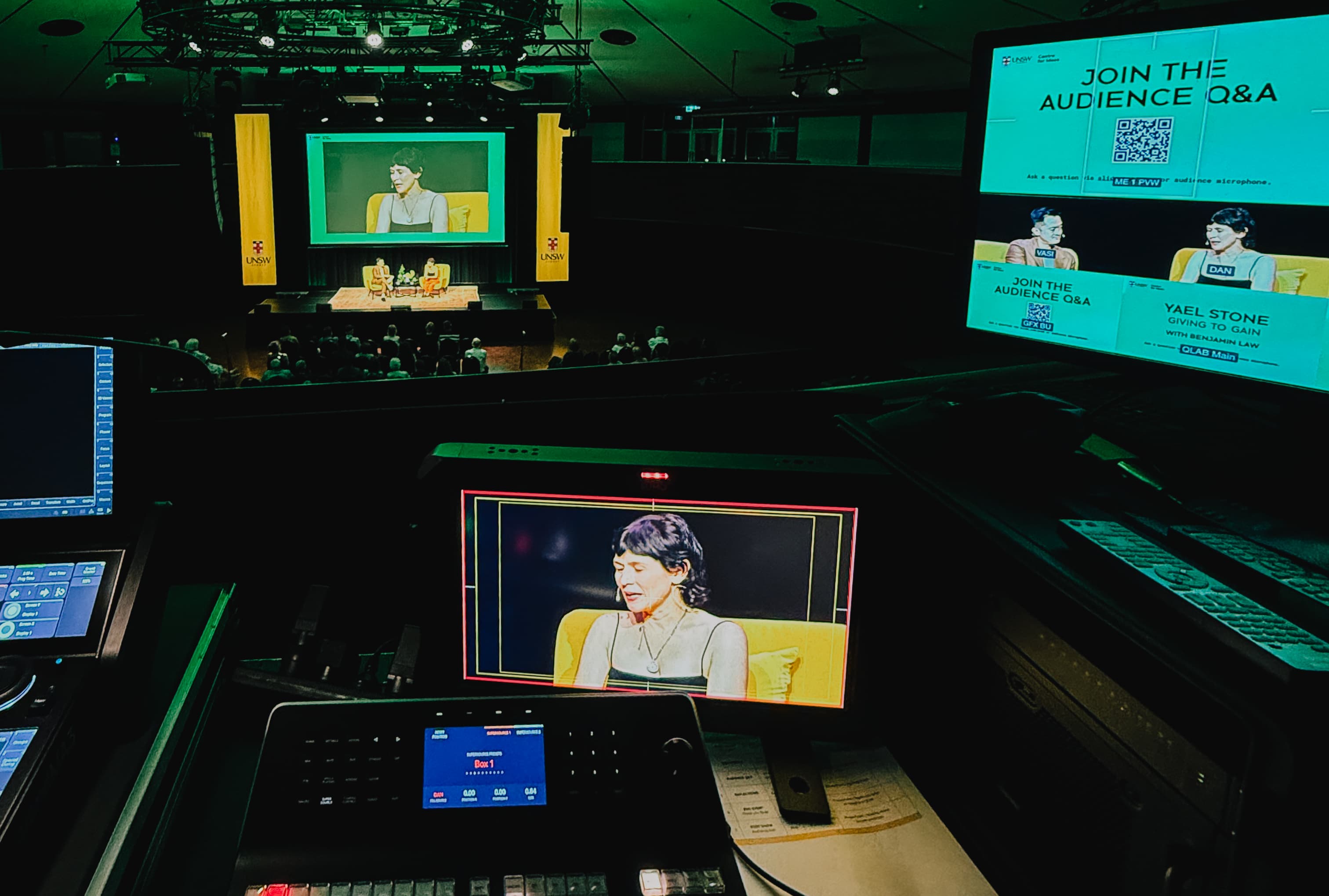 Conference audience and stage setup managed from a control position.